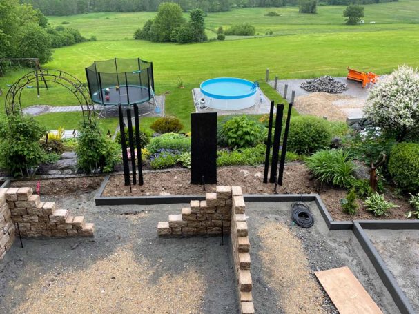 Gartenansicht mit Pool, Trampolin und neu gestalteten Landschaftselementen.