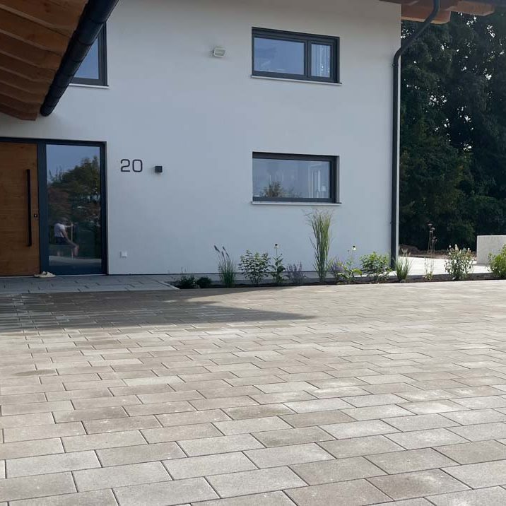Modernes Wohnhaus mit gepflastertem Vorbereich.
