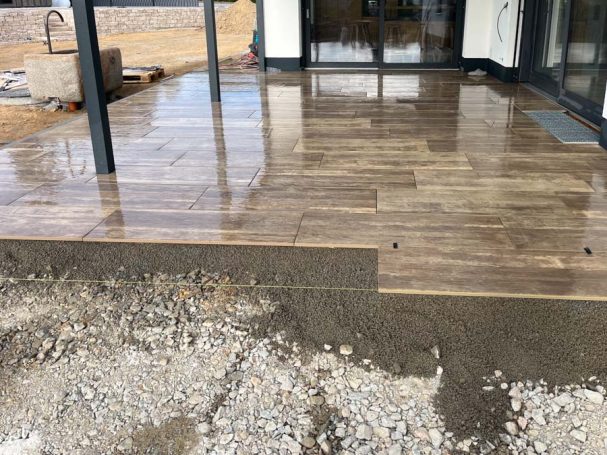 Holzboden auf einer Terrasse, teilweise noch unvollständig mit Schotter.