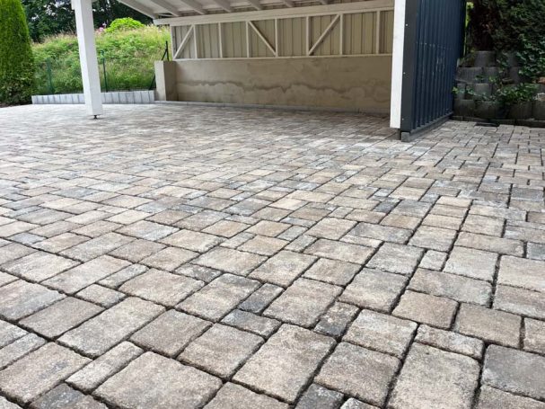 Gepflasterter Bereich mit rechteckigen Steinen in neutralen Farbtönen.